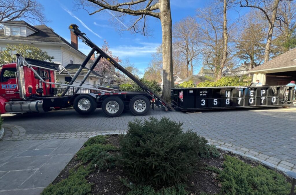 A Hiep Sanitation team member delivering construction dumpster rental in Nyack, NY, demonstrating the benefits of using a local professional for this essential service.