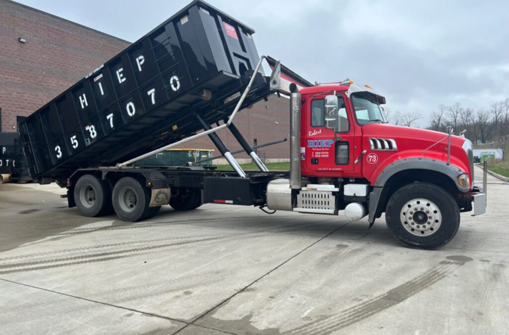 A Hiep Sanitation crew member delivering a construction dumpster in Haverstraw, NY, showcasing the ease and value of local waste solutions.