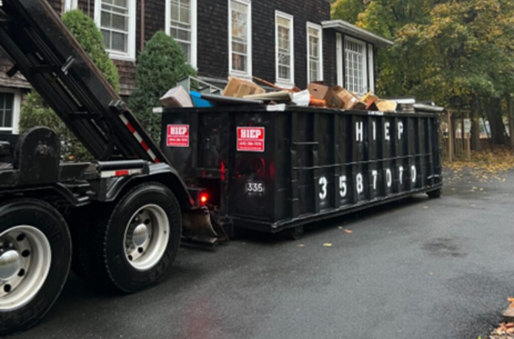 A Hiep Sanitation expert coordinating dumpster services at a Fort Lee, NJ construction zone, illustrating local expertise and reliability. Construction Dumpster Rental near me.